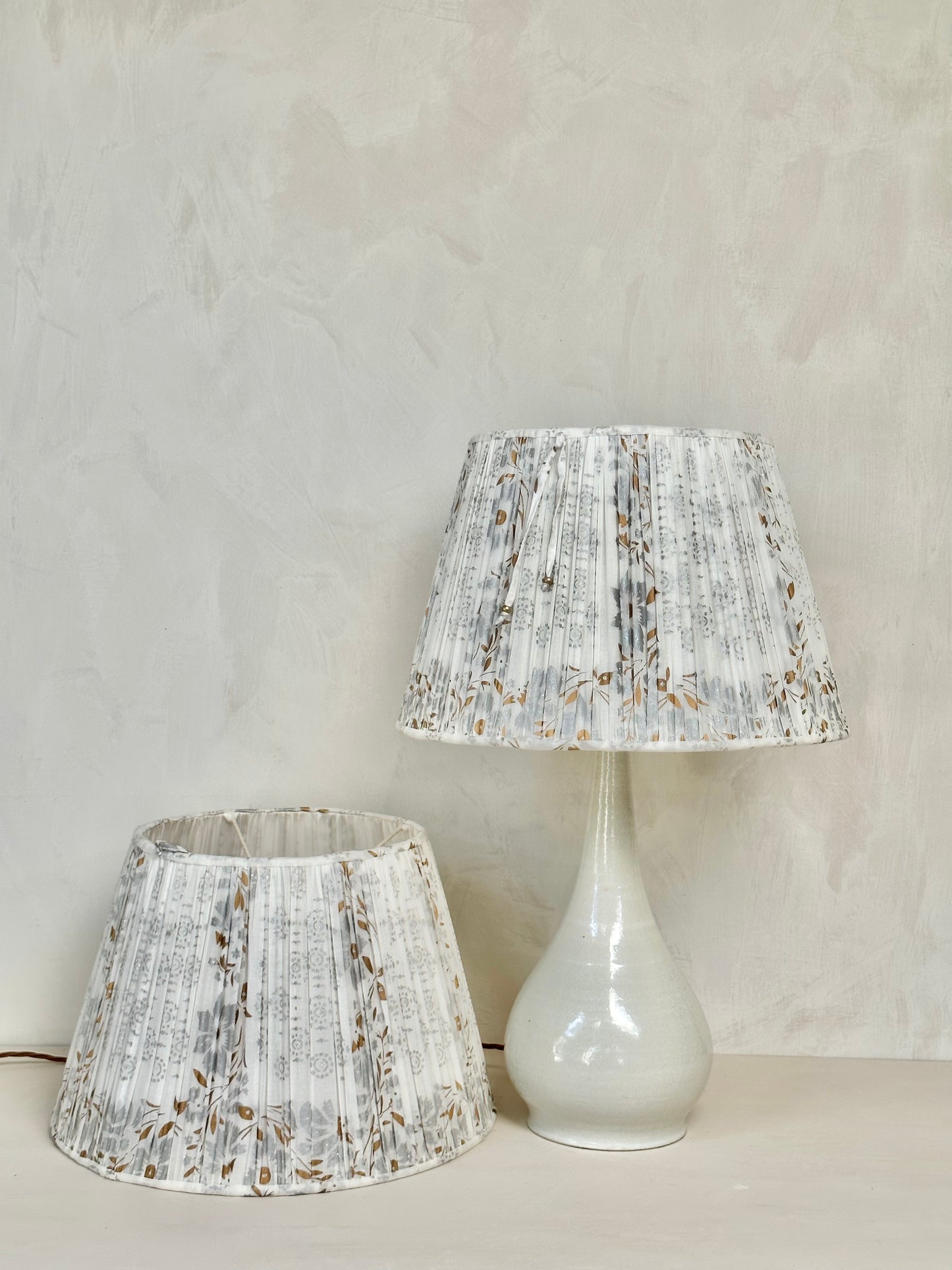 A pair of white, silver and gold sari lampshades