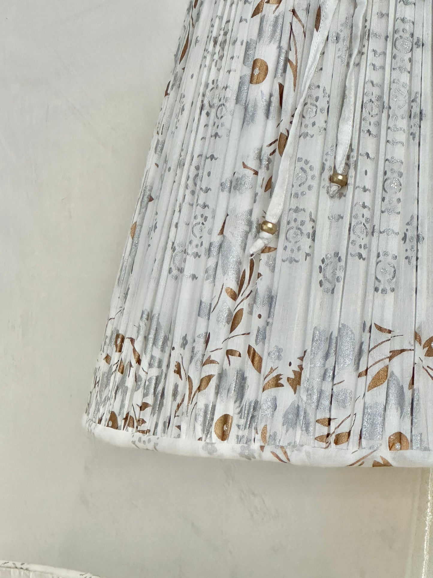 A pair of white, silver and gold sari lampshades