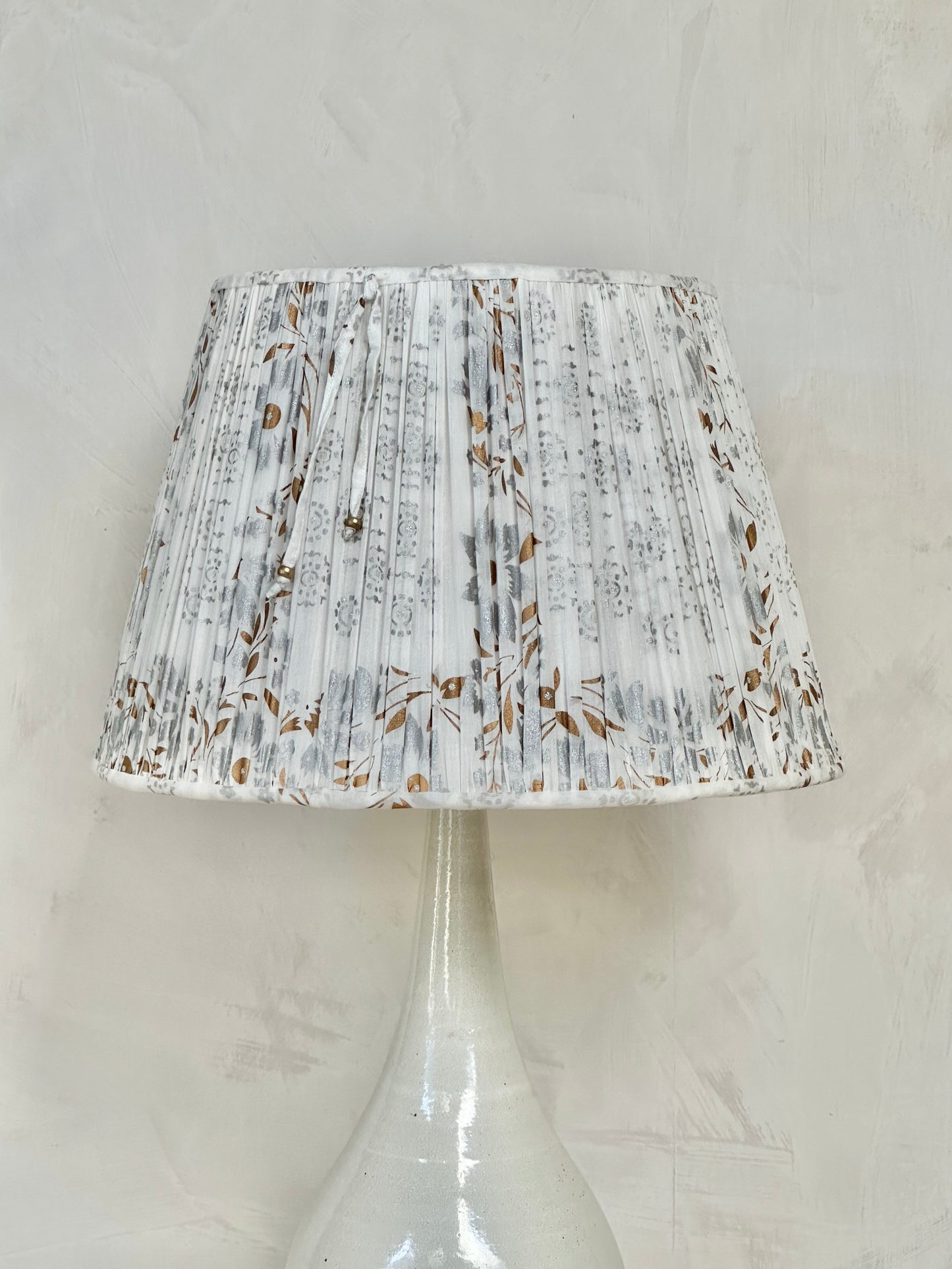 A pair of white, silver and gold sari lampshades
