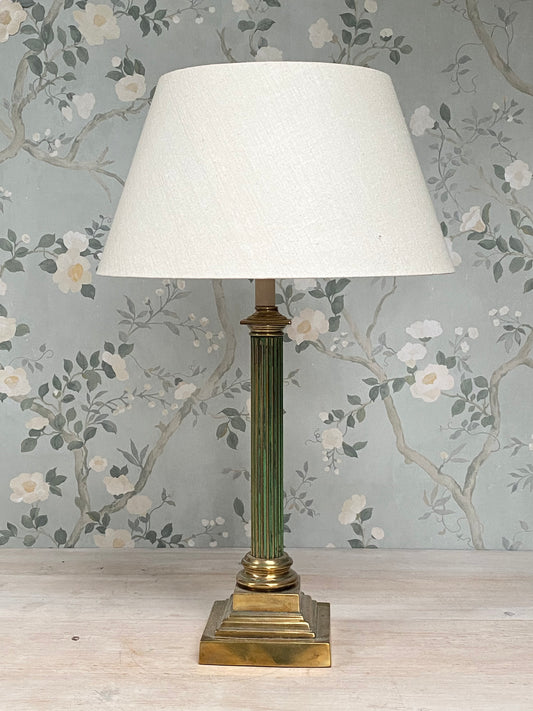 An antique fluted column lamp base with brass and gilt detailing and original green paint.