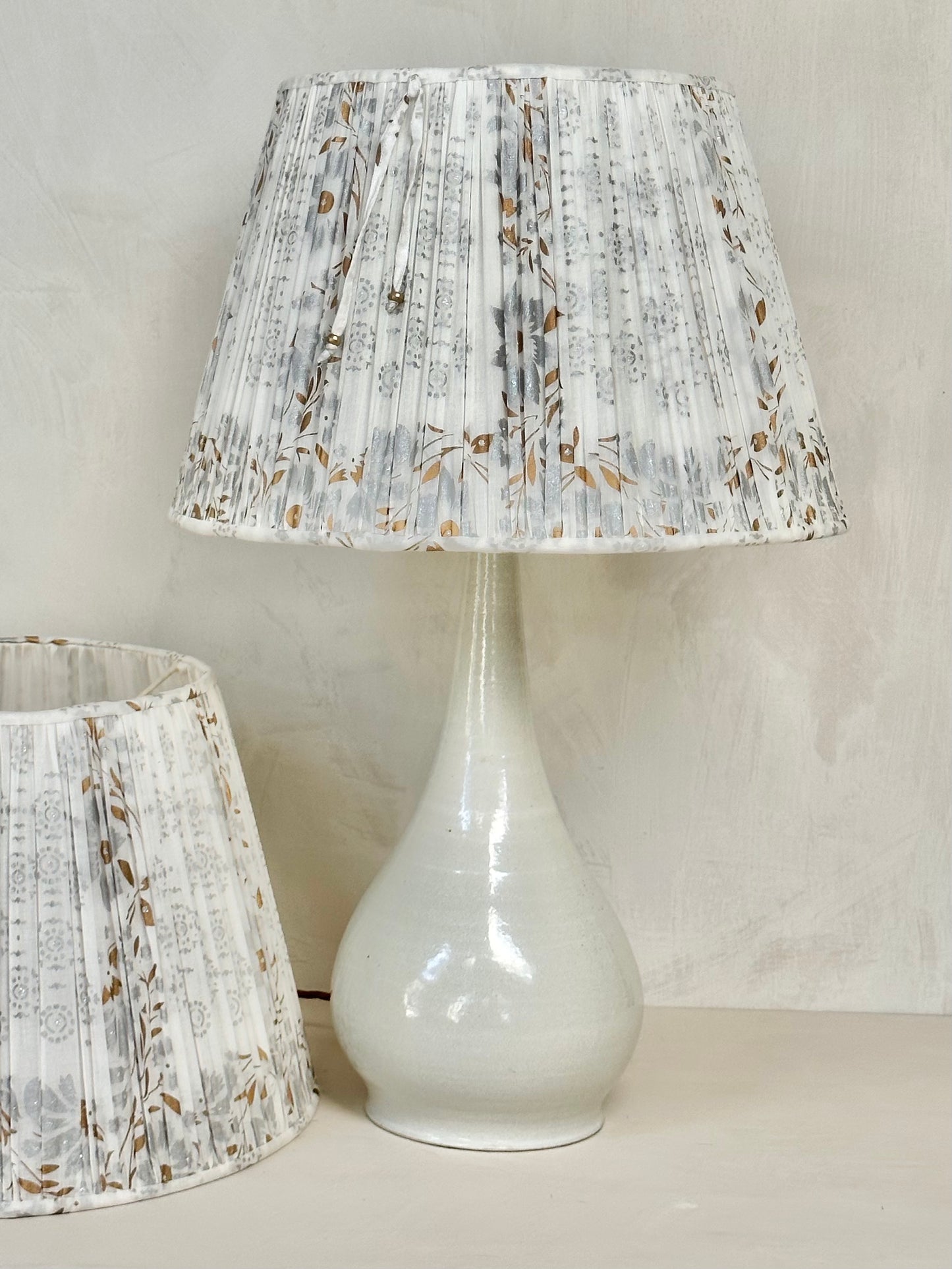 A pair of white, silver and gold sari lampshades