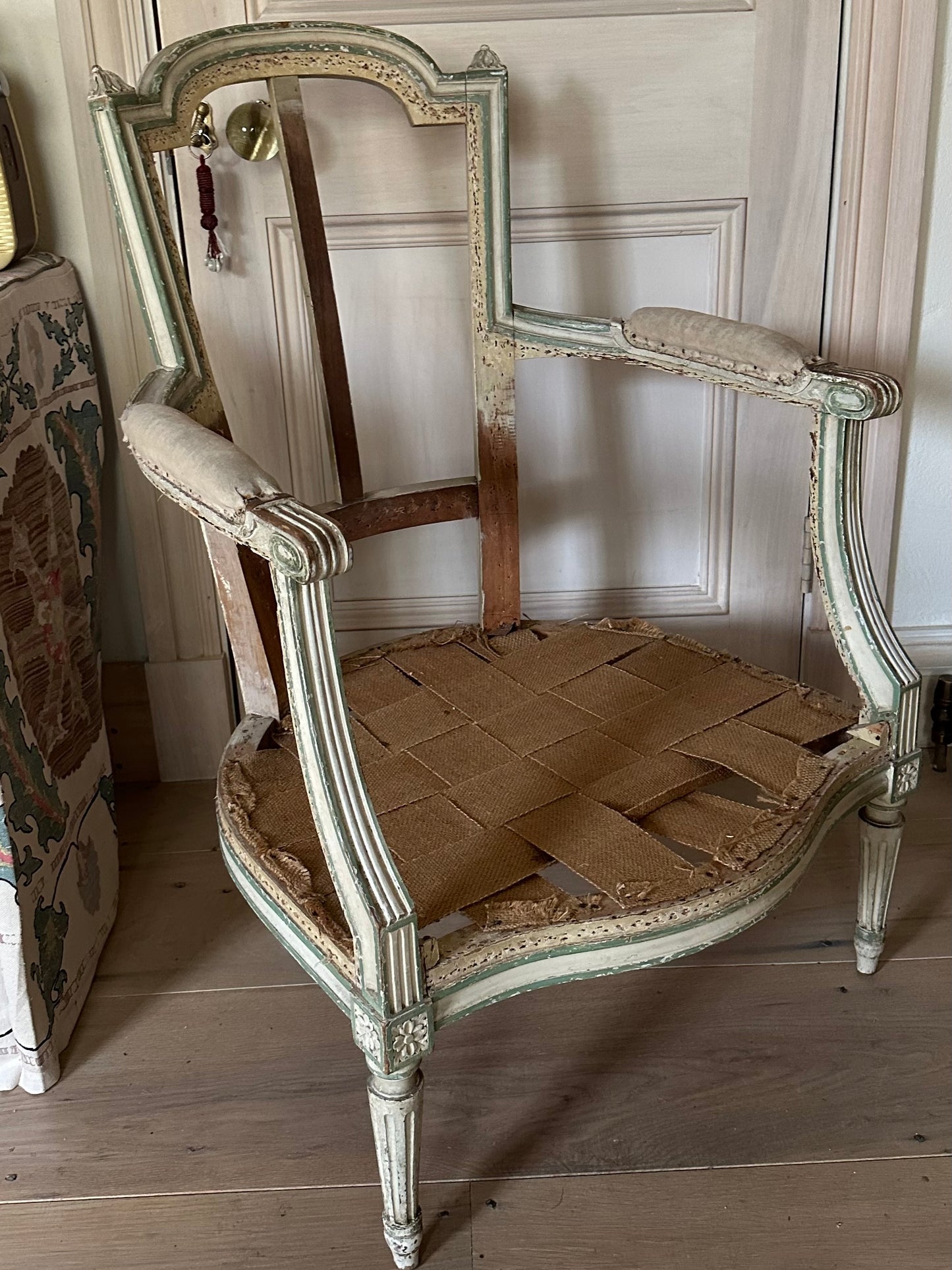 A french chair frame in its original green and off-white paint