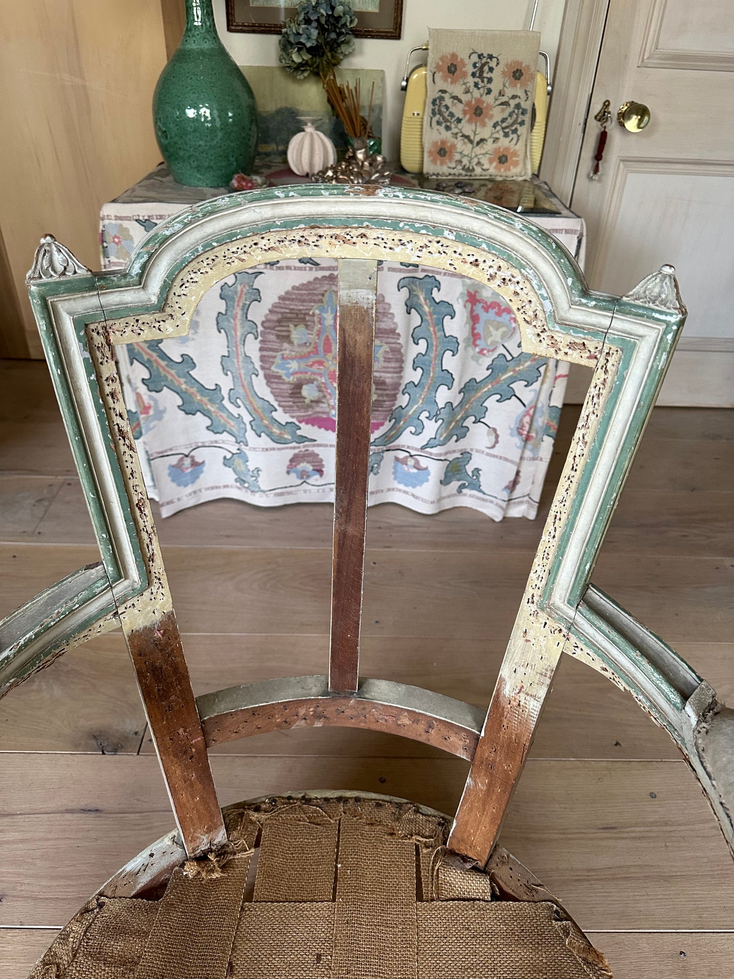 A french chair frame in its original green and off-white paint