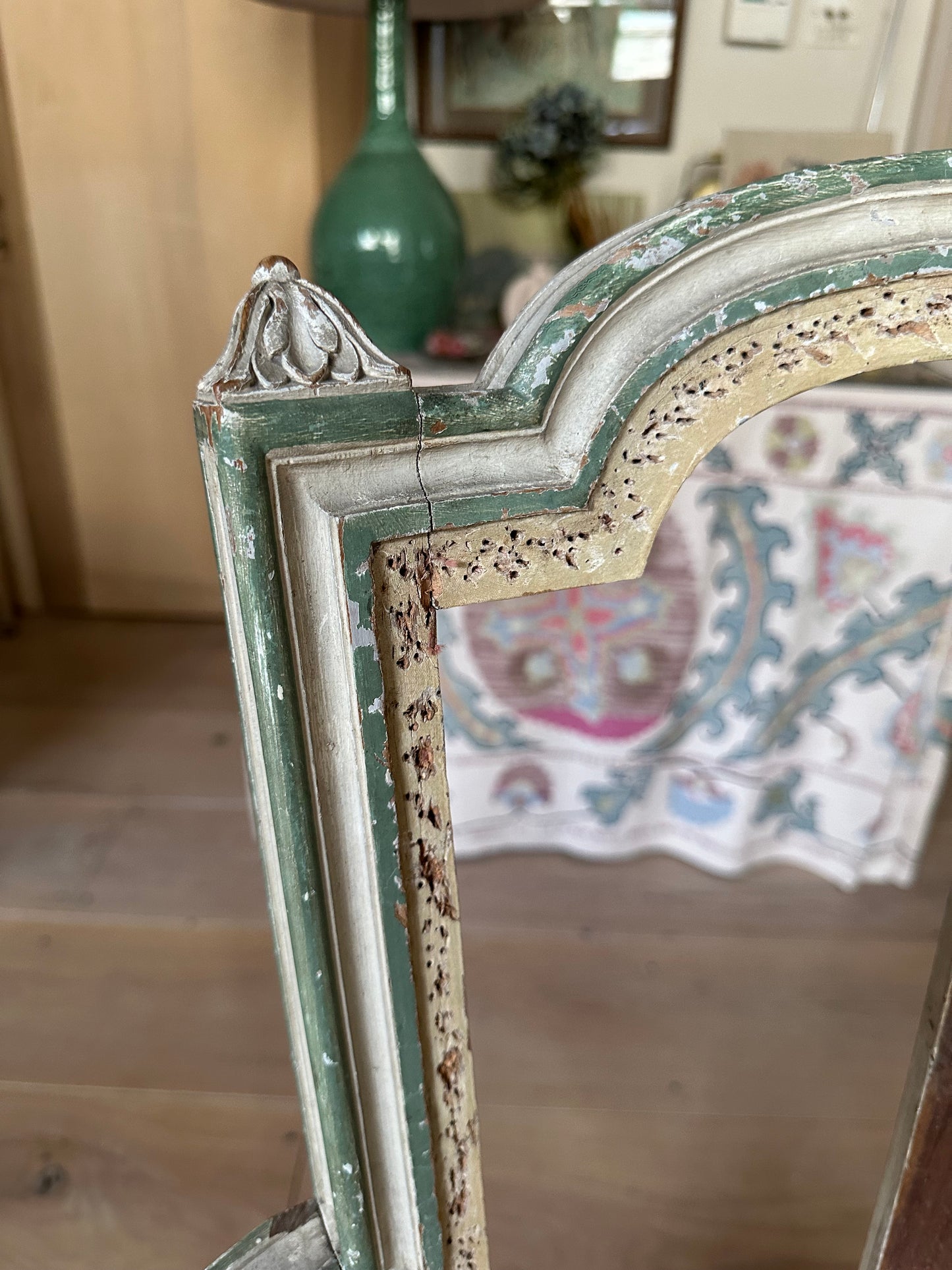 A french chair frame in its original green and off-white paint